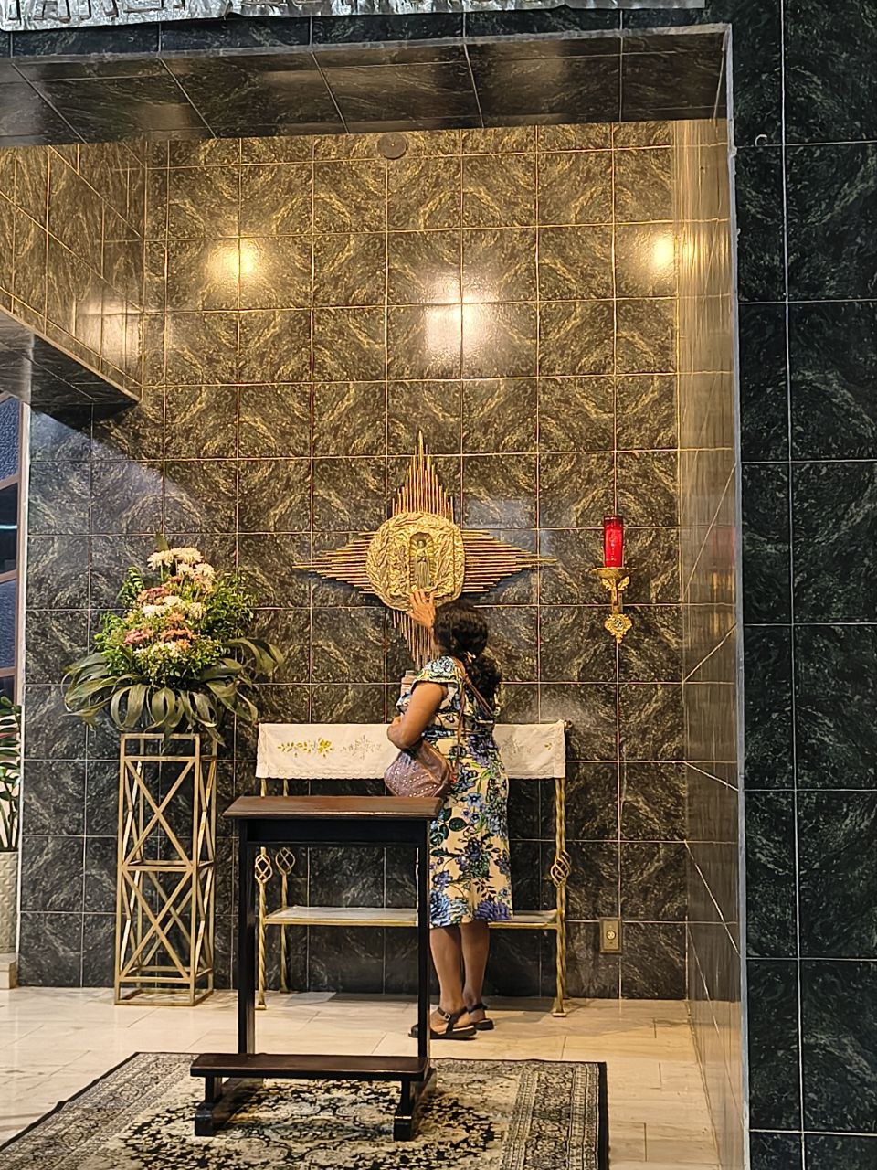 Mãos idosas segurando um terço com crucifixo dourado